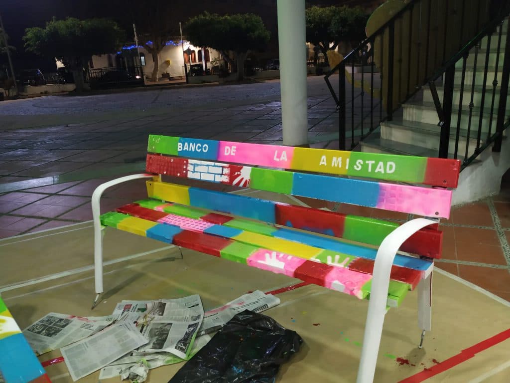 Niños y jóvenes de Lobres pintan el ‘Banco de la Amistad’ para luchar contra la discriminación y el acoso juvenil